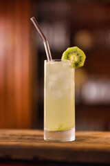 drink closeup with bar background standing on wooden plate with lamp on the left