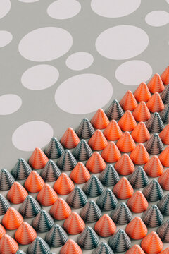 Three dimensional render of red and gray cones laid on polka dot pattern