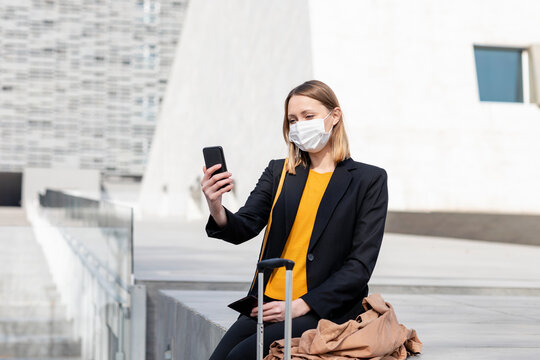 Female entrepreneur with face mask taking selfie though mobile phone
