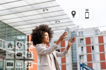 Businesswoman using transparent digital tablet with icons around outdoors