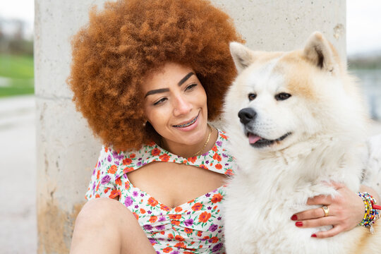 Smiling woman looking at fluffy dog