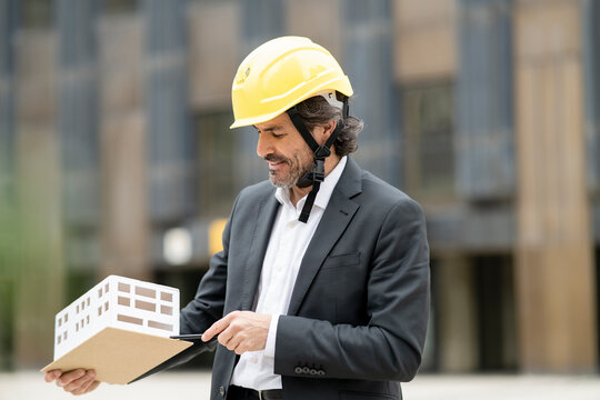 Male architect looking at architectural model