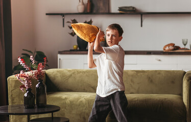 A teenager playing a game with a pillow in the room
