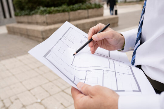 Mature male architect working on blueprint