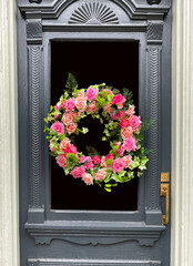 Wreath of beautiful pink roses on ornate old entry door