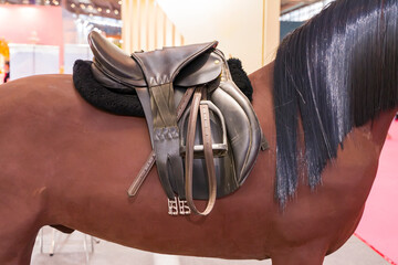 Saddle with stirrups on a back of a horse