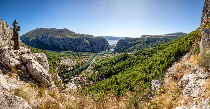 Croatia, Dalmatia, Omis, Statue of Mila Gojsalic overlooking settlement situated at forested bank of Cetina river in summer