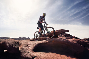 Fototapeta na wymiar Mountain biker rides at the desert scenic in Kazakhstan