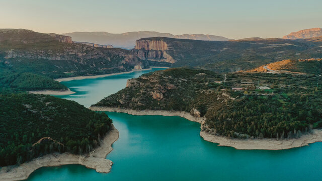 Aerial view of turquoise lake surrounded by forested landscape