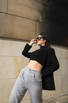 Woman adjusting sunglasses while bending over backwards