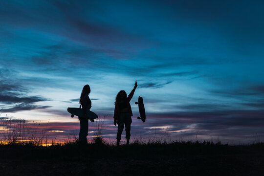 Female friends in silhouette during sunset