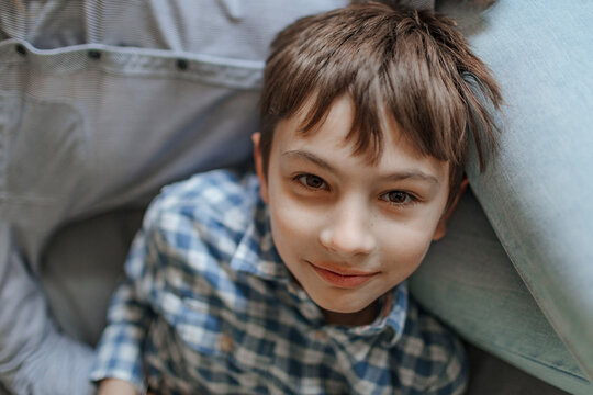 Smiling boy lying on mother's lap at home