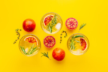 Red orange lemonade in glasses with ice and rosemary