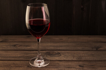Glass of red wine on an old wooden table