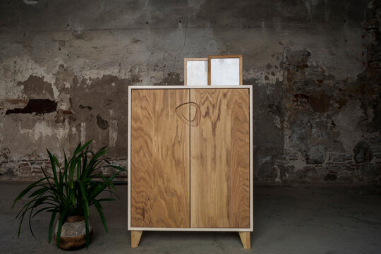 Blank picture frames standing on top of brown wooden cupboard