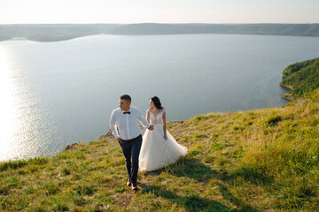 Sensual wedding couple groom and bride near the beautiful lake