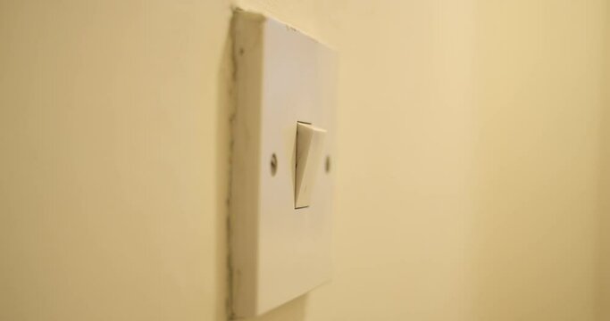 Finger switches on light switch.