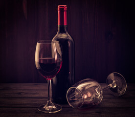 Bottle of red wine with two glasses on an old wooden table