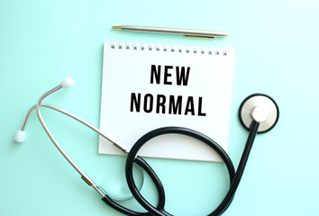 White notepad with the words NEW NORMAL and a stethoscope on a blue background.