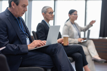 Mature businessman using laptop in conference room