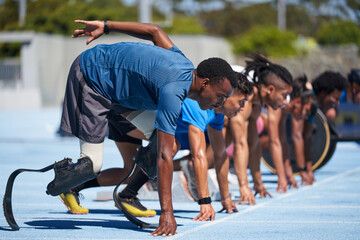 Amputee sprinters ready at starting line on sunny sports track