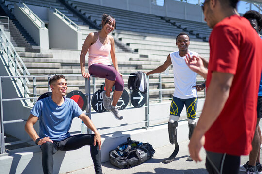 Young Athlete Friends Talking In Sunny Sports Stadium