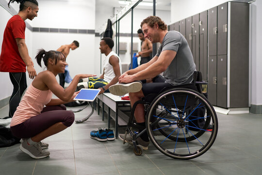 Coach and wheelchair athlete talking in locker room