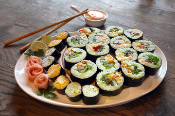 large set with sushi and rolls. sets of huge rolls size on white plates. huge plate with shushi