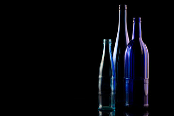 Drei Glasflaschen auf dunklem Hintergurnd, farbige Flaschen