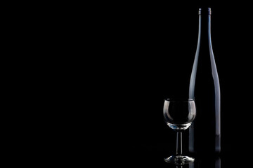 Weinflasche und Weinglas auf schwarz