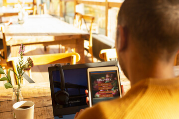 Male restaurant owner reviewing online delivery on digital tablet