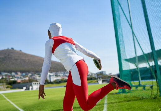 Female Track And Field Athlete In Hijab Throwing Discus