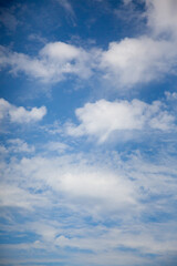 a sunny blue sky with fluffy white summer clouds suitable for use as a background