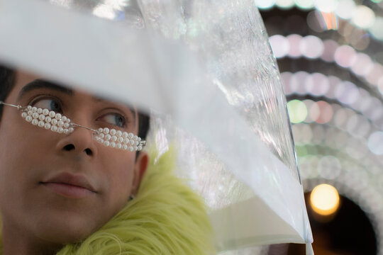 Close up stylish young man with pear glasses under umbrella
