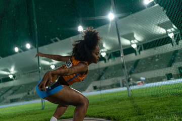 Female track and field athlete throwing discus at stadium competition