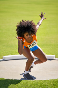Female track and field athlete throwing shot put