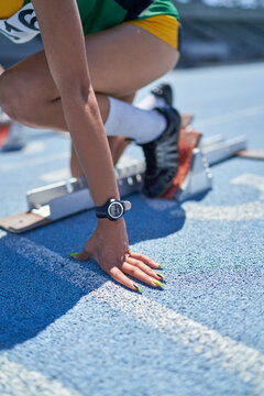 Close up female track and field athlete at starting block