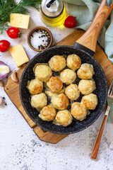 Homemade Meatballs with cheese sauce in a pan on a light stone or slate. Top view flat lay. Copy space.
