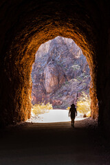 A Hiker walks toward the sunshine after passing through a tunnel along the Hoover Dam Historic...