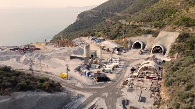 Concrete mixer trucks, concrete batching plant and construction materials at motorway tunnel construction site aerial view. State road D400, Mersin province, Turkey