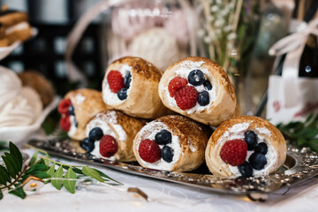 puff pastry rolls filled with cream and decorated with blueberries and raspberries
