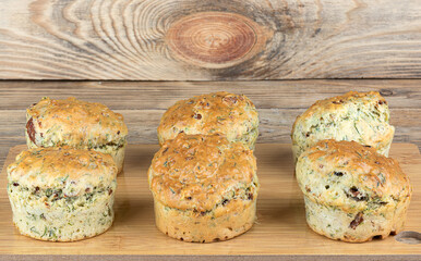 Freshly baked muffins with dill and bacon on a cutting board.