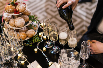 champagne is poured into glasses on the buffet table