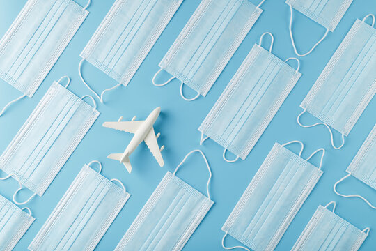 White airplane around protective masks on a blue background