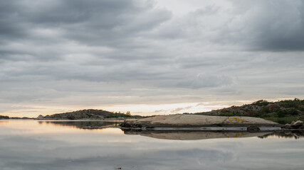 Beautiful summer night on the Swedish west coast. Calm sea, sunset and clouds.