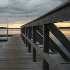 Wooden bridge to the water. Calm summer night on the Swedish west coast.