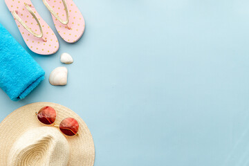 Straw beach womans hat with sun glasses on sand. Top view