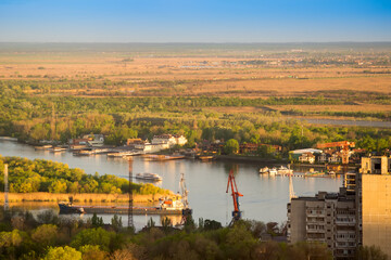 Obraz premium Top view of the river and the river port. Urban landscape, barges floating on the river in the distance, a train rides
