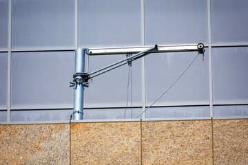 Swiveling davit arm is attached to the building rooftop structure