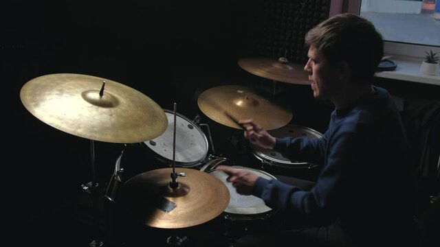 Man play the drum set in studio. Male drummer playing at drums with brushes. Home lesson training.